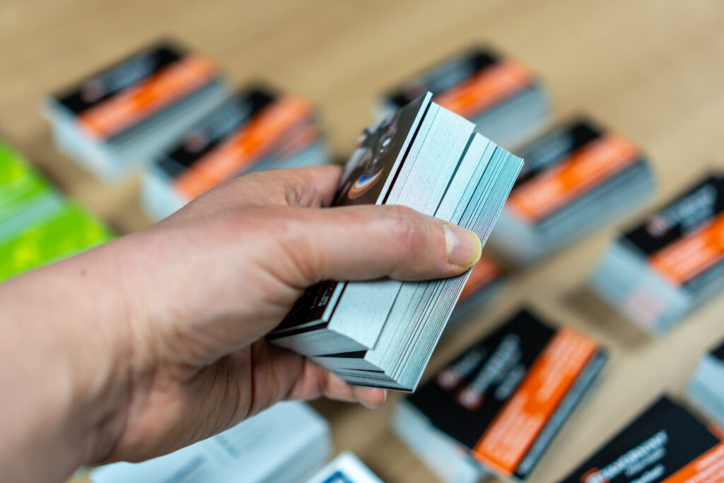 A worker's hand holding a package of printed business cards in a printing plant.